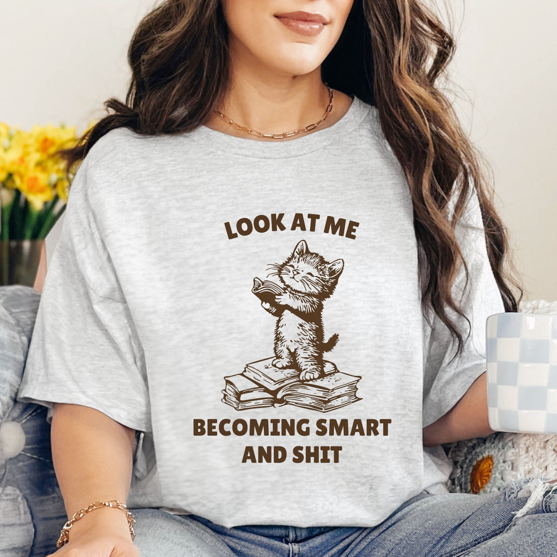 Humorous Cat Reading T-Shirt – 'Look at Me Becoming Smart and Sh*t' – Unisex Graphic Tee for Book Lovers-Ash-Family-Gift-Planet